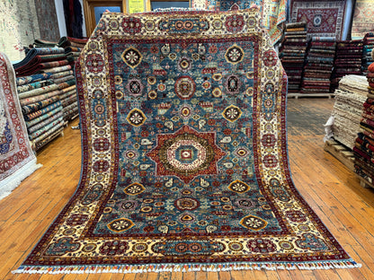 Decorative rug with intricate patterns on a wooden floor in a store setting.