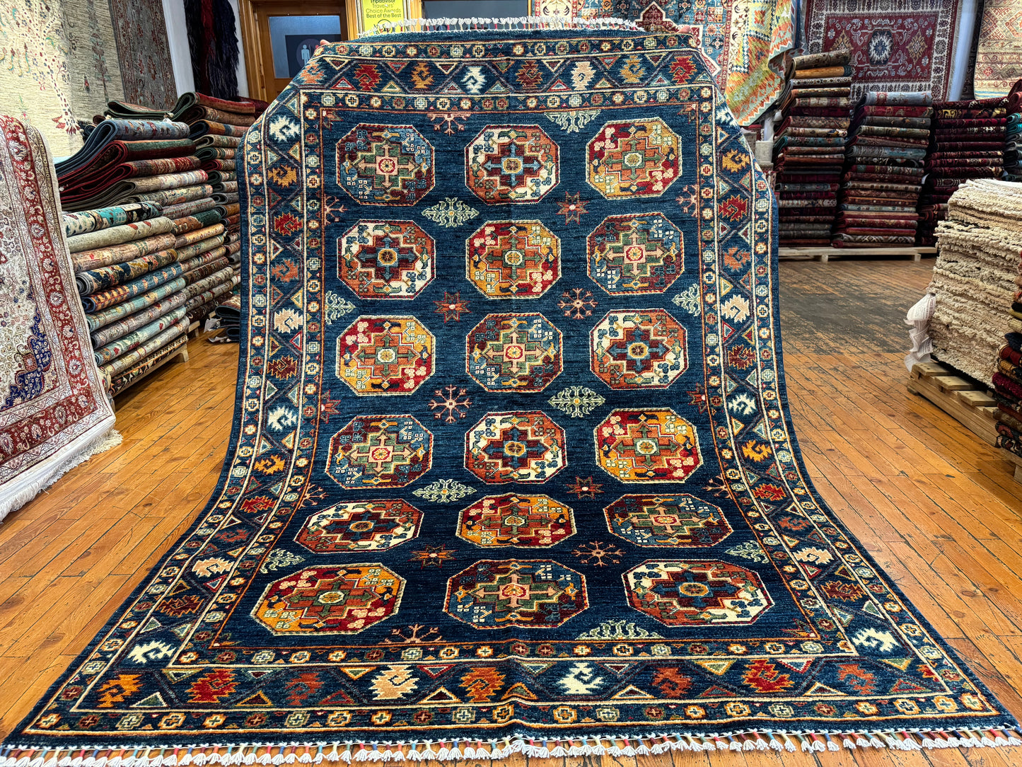 Decorative rug with geometric pattern on a wooden floor in a store setting