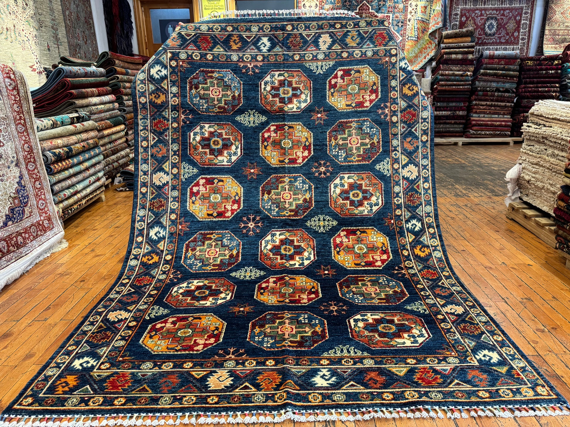 Decorative rug with geometric pattern on a wooden floor in a store setting